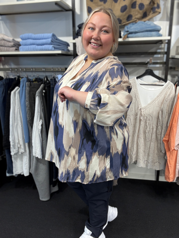 Plus size blusen Bella er i de smukkeste blå, beige og sand farver. Den er med v-hals, og ærmer der har en smule ballon-effekt. Det er en 100% viskose bluse, som kan bruges året rundt.