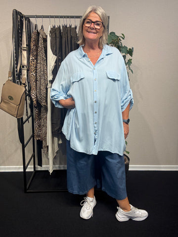 Inge er plus size skjorten, som kan passes af de fleste. Den er dejlig lang, da den har en længde på hele 84cm. Brug den som en åben jakke eller helt lukket, den er nemlig gennemknappet.