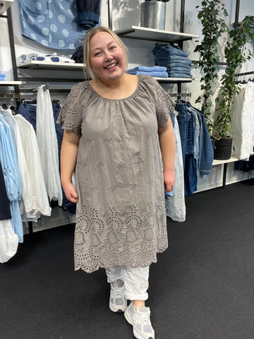 Sød og sommerlig kjole med broderingsdetaljer. Den har elastik i halsen, og er med korte ærmer. Den er i 100% bomuld. Her ses den i farven Taupe.