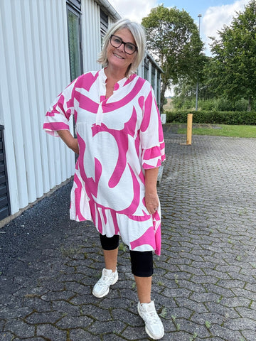 Nikoline er plus size tunikaen i a-facon og v-halsen med den runde krave. Den er med 3/4 ærmer med trompet effekt. Derudover findes den i flere friske farver.