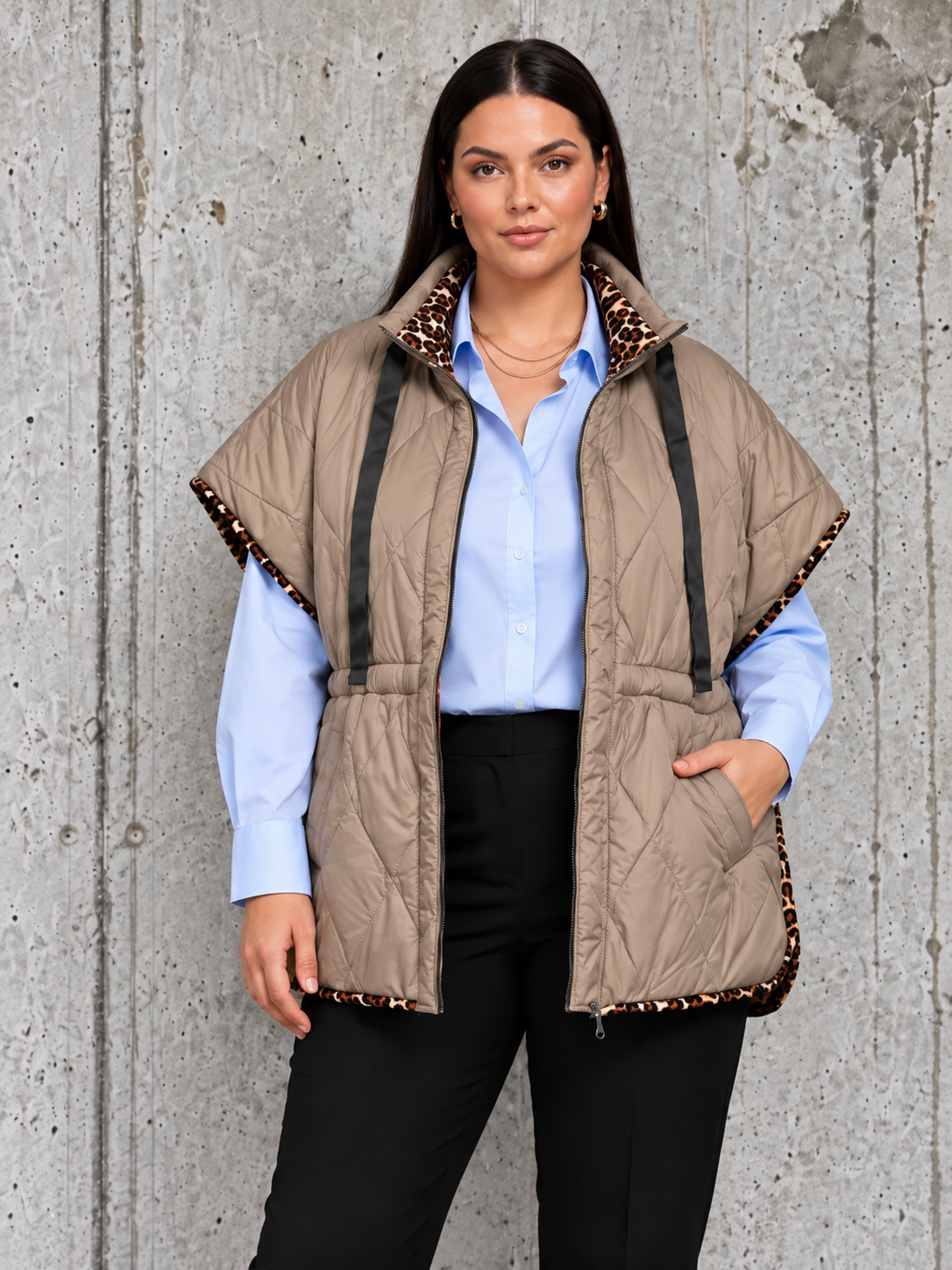 Plus size model iført quiltet vest med flot pasform, høj krave, praktiske lommer og dekorative leoparddetaljer. En blød og komfortabel vest til plus size kvinder, perfekt til både hverdagsbrug og lag-på-lag styling.