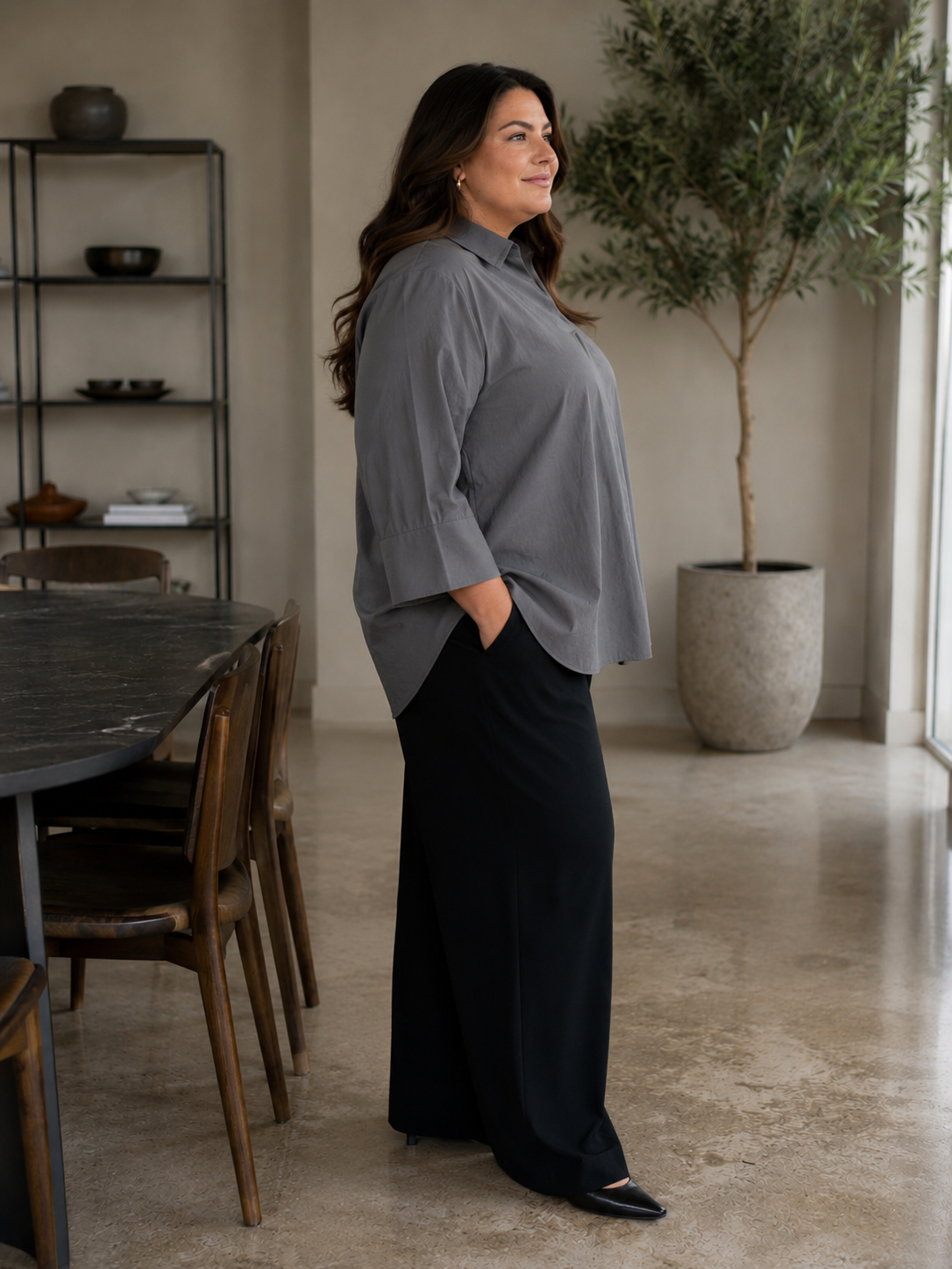En plus size skjorte med krave, brede 3/4 ærmer. Den har en god længde og går ned og dækker det vi gerne vil ha' dækket. 

Billedet er genereret vha. AI.