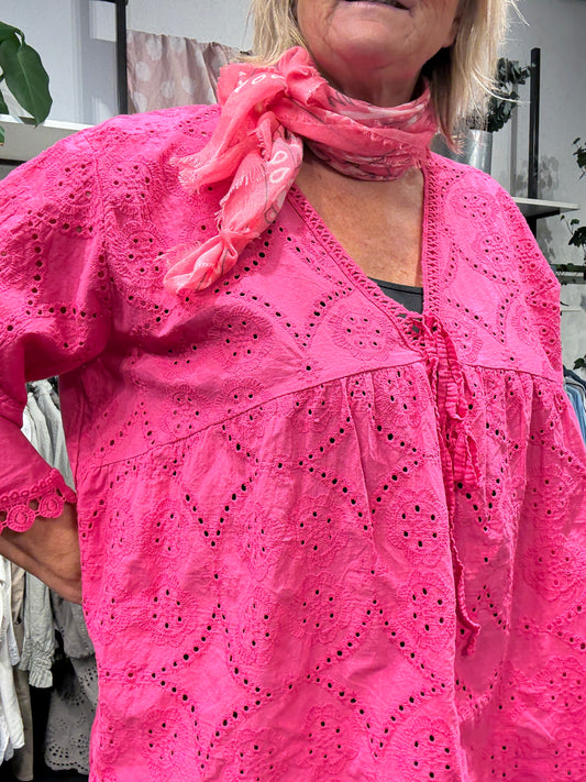 Plus size tunikaen "Anni" fra Sigensgaard har en rigtig god facon, som gør at de fleste plus size piger vil blive glad for den. Den er med trompet-ærmer, v-hals og smukke broderingsdetaljer. Her ses den i farven pink.
