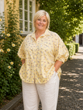 Sød plus size skjorte med hunde på. Den er med 3/4 ærmer og er gennemknappet så den kan bruges både åben og lukket. 

Billedet er genereret vha. AI.