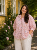 Sød plus size skjorte med hunde på. Den er med 3/4 ærmer og er gennemknappet så den kan bruges både åben og lukket. 

Billedet er genereret vha. AI.
