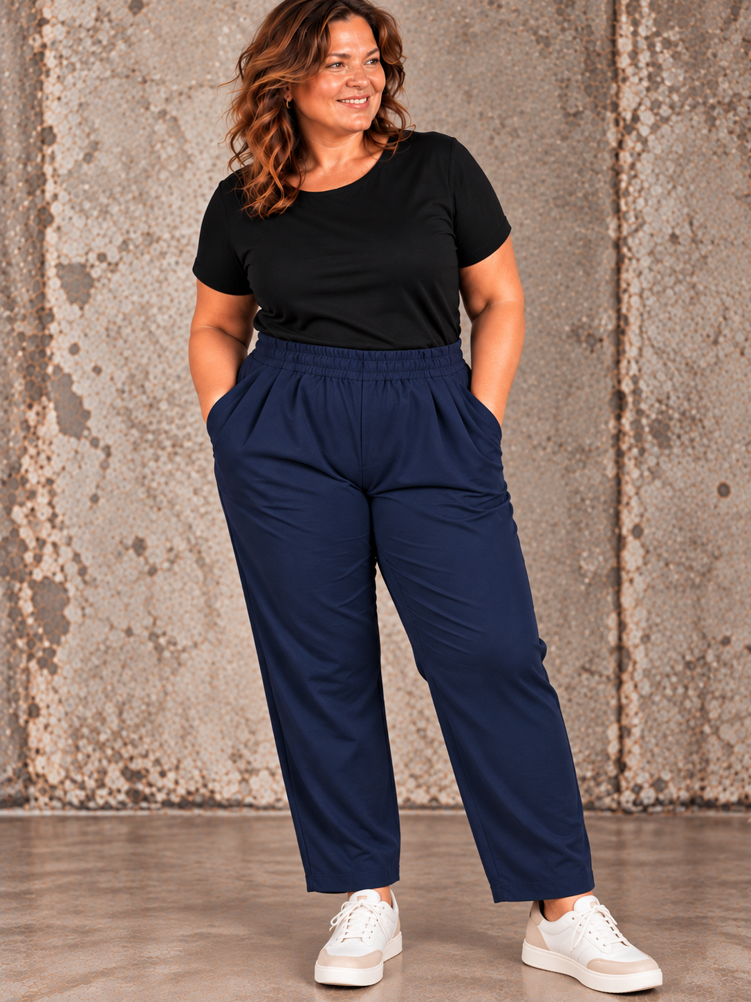 **SEO alt-tekst:**

Anni plussize buks i marineblå med elastik i taljen og praktiske sidelommer, vist på curvy model. Billedet er AI-genereret.
