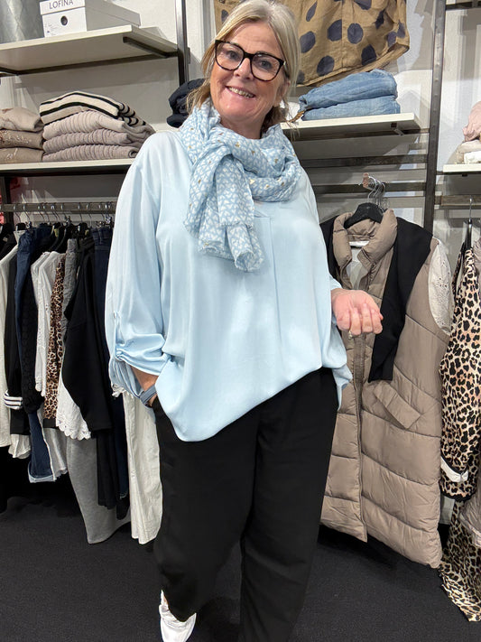 Lækker plus size viskose tunika ved navn Belinda, som falder tungt. Den er med en dyb v-hals, og har lange ærmer med elevatorhejs. Den er er specielt god hvis man er udfordret når det kommer til ærmevidde. Her ses den i den flotte lyse blå.
