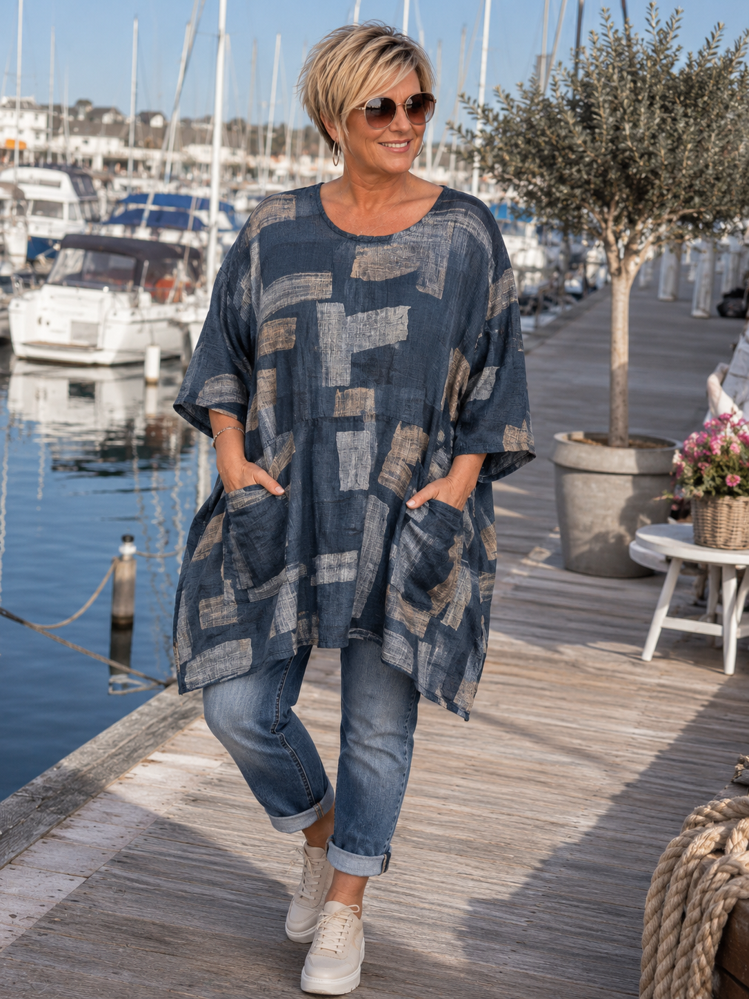AI-genereret billede af Sille plussize bomuldstunika i let vævet bomuld med grafisk print, rund hals og lommer. Tunikaen vises på en plus-size model og fås i flere farver.