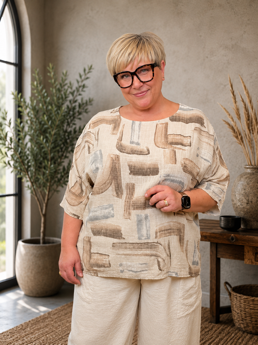 Bodil bluse i blød og let bomuld med et moderne, grafisk print. Blusen har en afslappet, rummelig pasform, rund hals og 3/4-ærmer, som giver et komfortabelt og stilfuldt look. Den er nem at kombinere med både hørbukser, jeans og shorts og fås i flere flotte farver. Perfekt til kvinder, der ønsker en luftig bomuldsbluse med god bevægelsesfrihed og et moderne udtryk.billed er ai generet