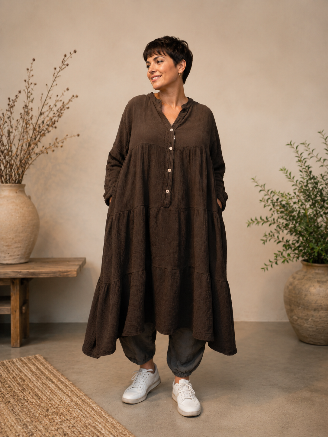 Ella plus size kjole i mørk marineblå med V-hals, knapper, 3/4 ærmer og flot vidde – stylet med sorte leggings og karamel sneakers.
Billed er ai generet