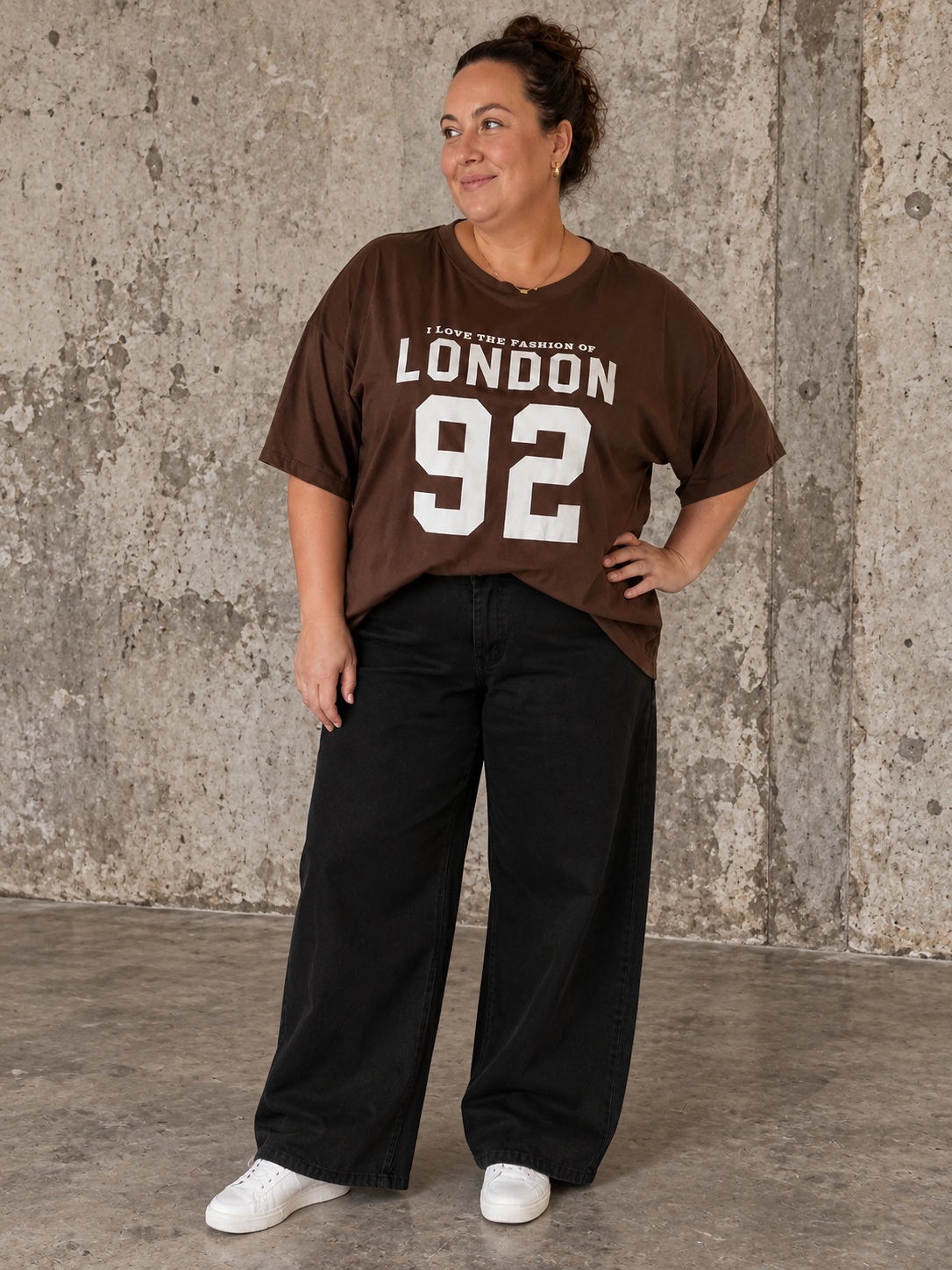 London T-shirt er en afslappet og moderne oversize T-shirt i blød bomuld, designet til plus size kvinder. Modellen har rund hals, korte ærmer og et cool "London 92"-print på brystet, som giver et sporty og trendy look. Den løse pasform gør T-shirten utrolig behagelig at have på og nem at style med jeans, shorts, leggings eller hørbukser. Fås i flere flotte sommerfarver og er perfekt til både hverdag, ferie og afslappede sommerdage.billed er ai generet