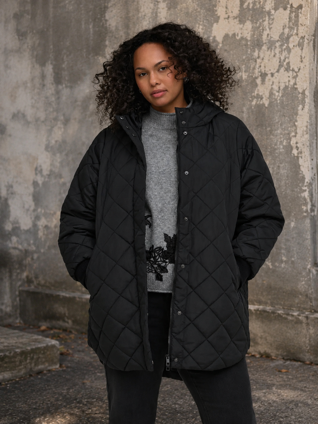 CarJuliet plussize quiltjakke i sort med flot quiltet mønster, høj krave og praktiske sidelommer. Rummelig pasform til plus size. Billedet er AI-genereret.