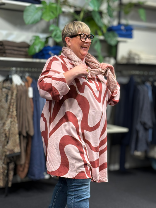 Anderledes tunika til plus size kvinden. Den er med stolpelukning, lange ærmer og en klassisk skjortekrave. 