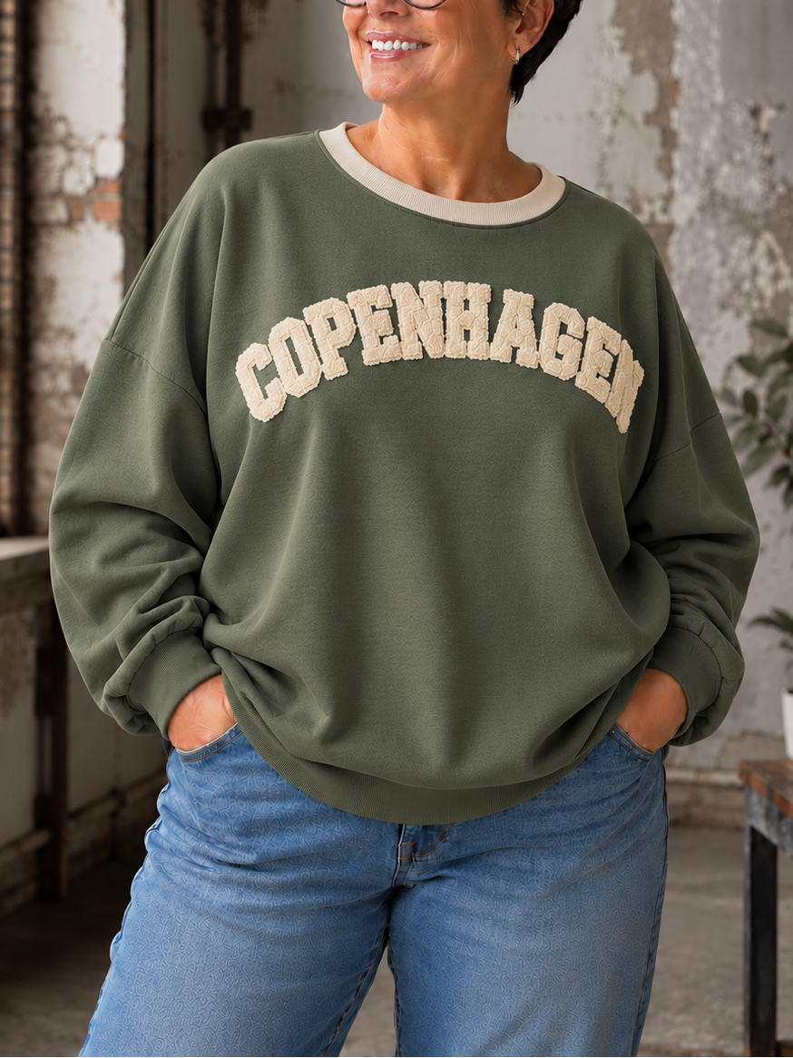 Smart sweatshirt med print foran, hvor der står "Copenhagen". Den er i en smørblød kvalitet som er virkelig dejlig at ha' på - det er en af dem vi bruger til hverdag, men bestemt også til søndagsafslapning. Perfekt til plus size kvinden som ønsker en behagelig sweatshirt. 

Billedet er genereret vha. AI-teknologi.