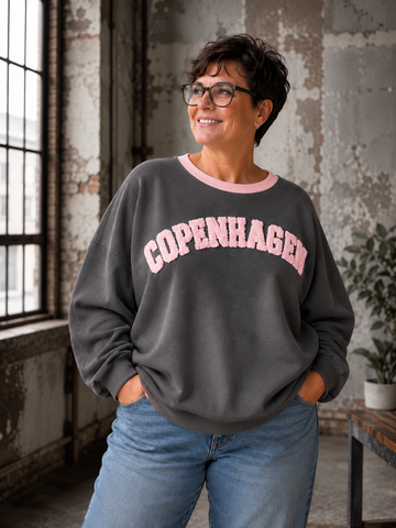 Smart sweatshirt med print foran, hvor der står "Copenhagen". Den er i en smørblød kvalitet som er virkelig dejlig at ha' på - det er en af dem vi bruger til hverdag, men bestemt også til søndagsafslapning. Perfekt til plus size kvinden som ønsker en behagelig sweatshirt. 

Billedet er genereret vha. AI-teknologi.