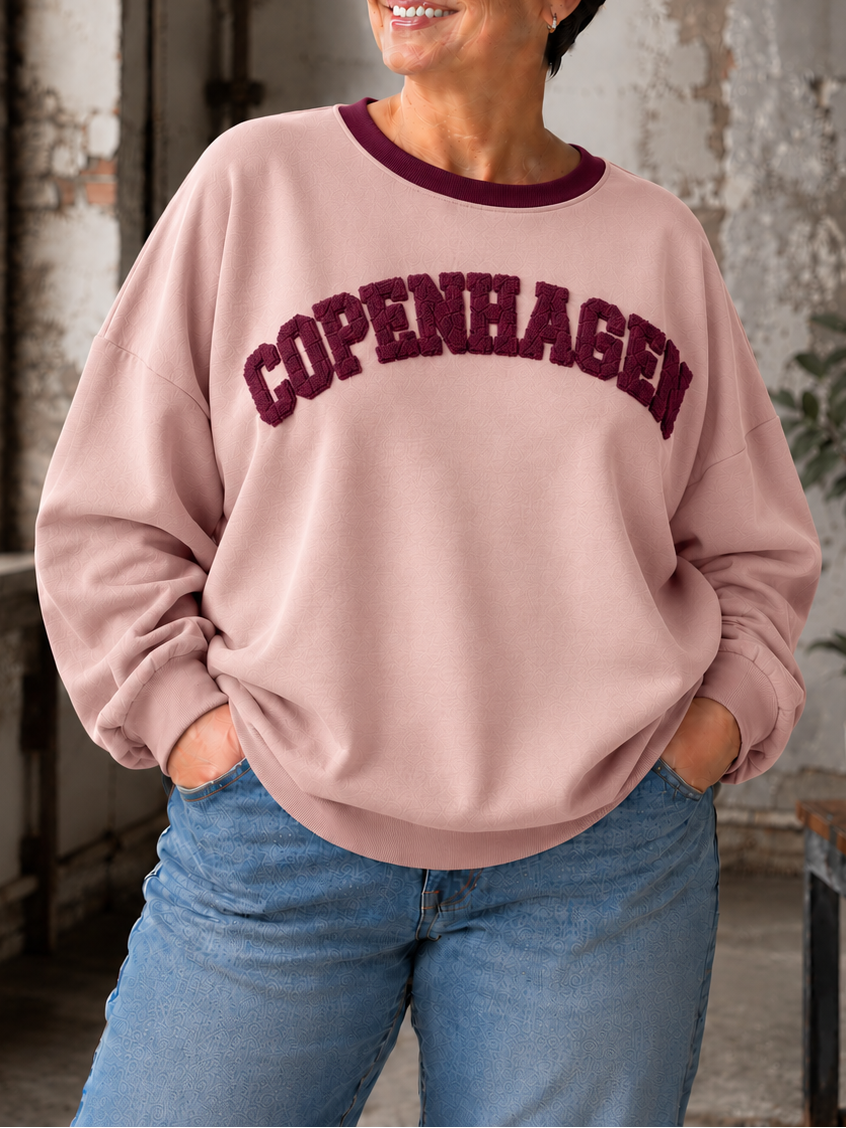 Smart sweatshirt med print foran, hvor der står "Copenhagen". Den er i en smørblød kvalitet som er virkelig dejlig at ha' på - det er en af dem vi bruger til hverdag, men bestemt også til søndagsafslapning. Perfekt til plus size kvinden som ønsker en behagelig sweatshirt. 

Billedet er genereret vha. AI-teknologi.