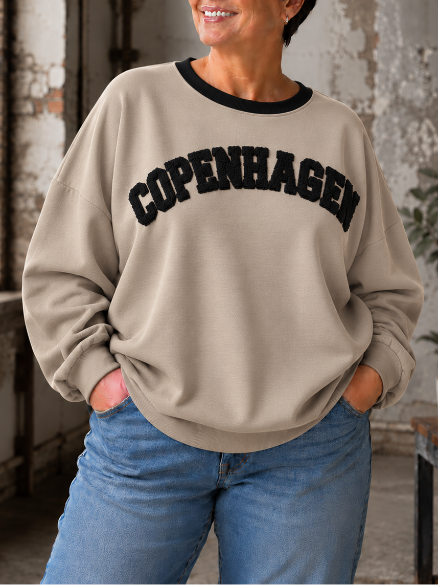 Smart sweatshirt med print foran, hvor der står "Copenhagen". Den er i en smørblød kvalitet som er virkelig dejlig at ha' på - det er en af dem vi bruger til hverdag, men bestemt også til søndagsafslapning. Perfekt til plus size kvinden som ønsker en behagelig sweatshirt. 

Billedet er genereret vha. AI-teknologi.