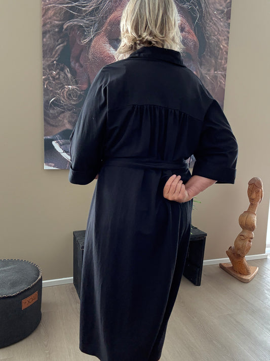 Smart plus size kjole med bælte der definerer taljen. Den er med v-hals, korte ærmer og krave. Fås fra en str. 42 til og med str. 54.