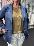 Smart denim blazer som er god til plus pigen grundet den gode facon. Den er med 2 pyntelommer og knaplukning med 2 store knapper. Den er blød i kvaliteten, hvilket gør den rigtig behagelig at have på.