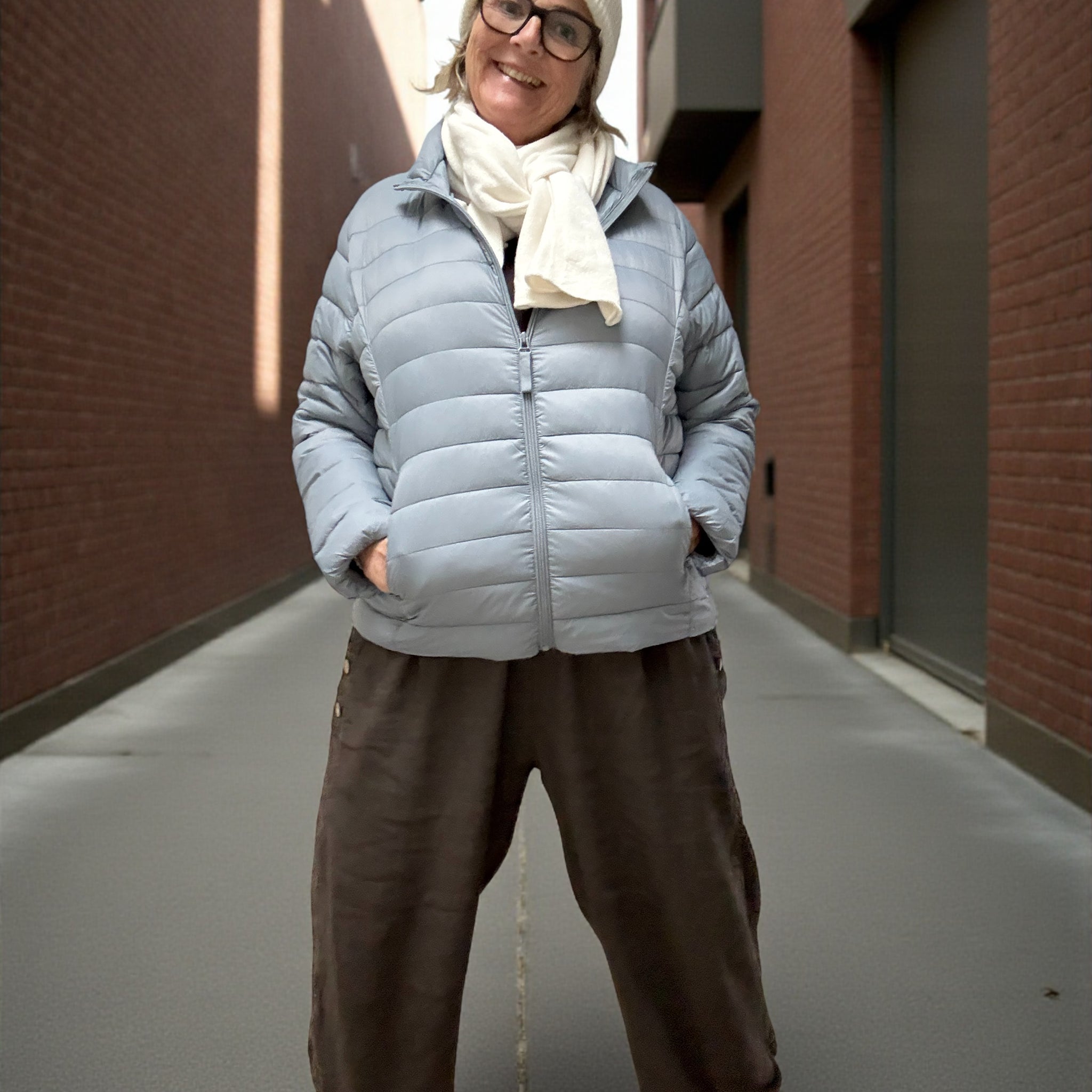 Jakken har høj hals, lange ærmer, lynlås foran og praktiske sidelommer med lynlås. Den er let foret med blød, syntetisk fyld, som giver god varme uden at virke tung.