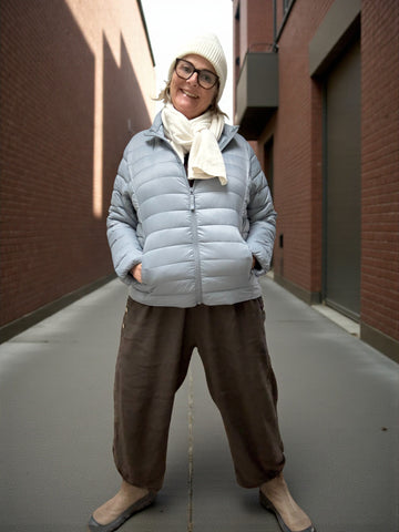 Jakken har høj hals, lange ærmer, lynlås foran og praktiske sidelommer med lynlås. Den er let foret med blød, syntetisk fyld, som giver god varme uden at virke tung.