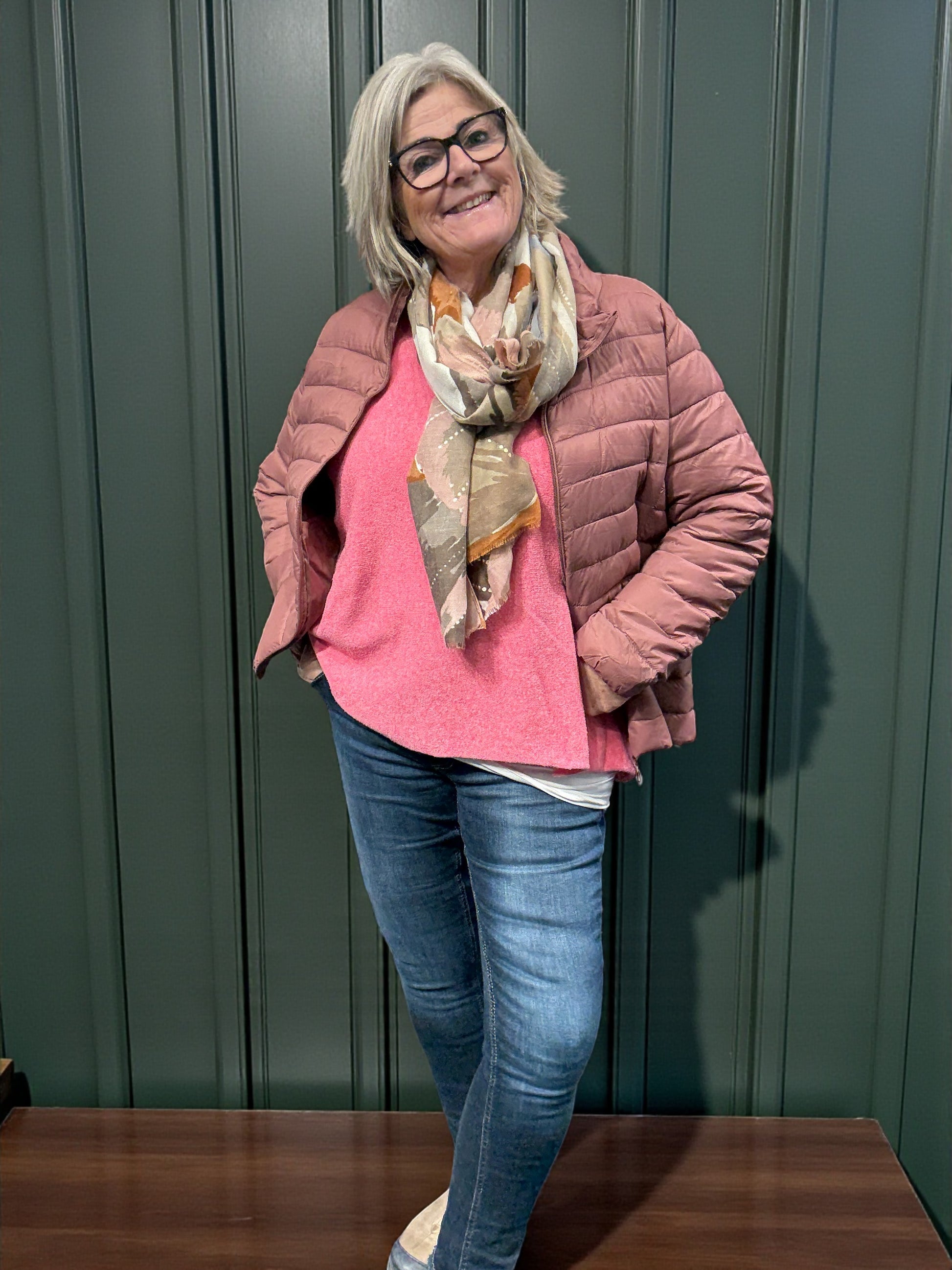 Jakken har høj hals, lange ærmer, lynlås foran og praktiske sidelommer med lynlås. Den er let foret med blød, syntetisk fyld, som giver god varme uden at virke tung.