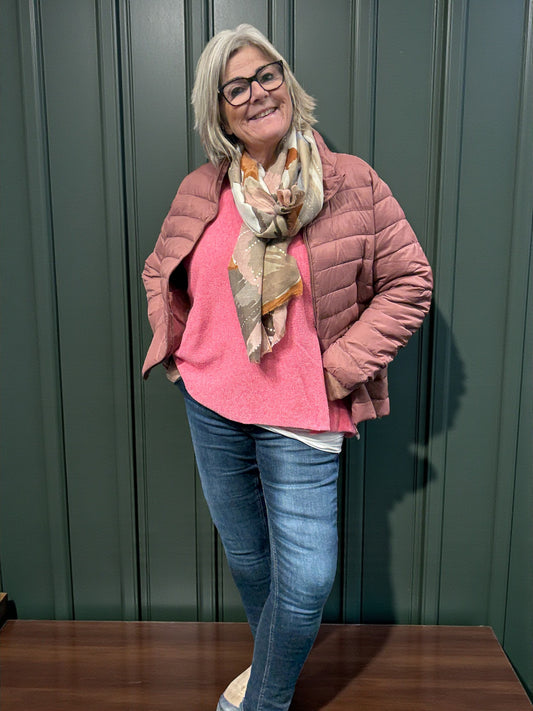 Jakken har høj hals, lange ærmer, lynlås foran og praktiske sidelommer med lynlås. Den er let foret med blød, syntetisk fyld, som giver god varme uden at virke tung.