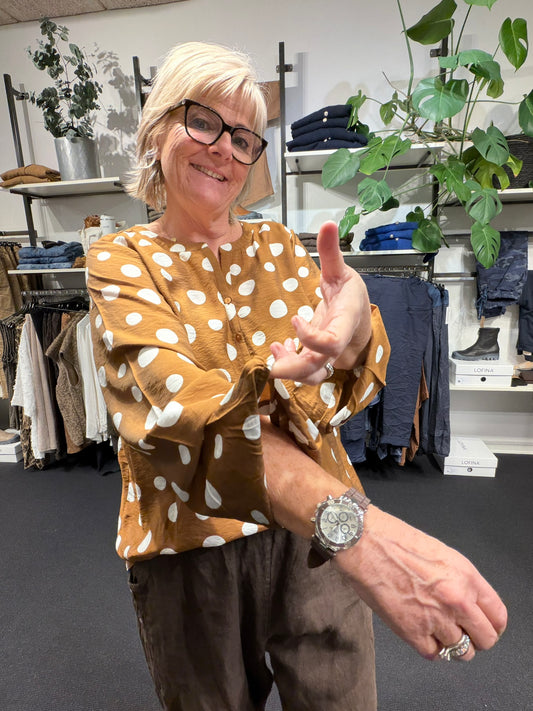 Smuk bluse med prikker og stolpelukning. Perfekt til plus size kroppen.