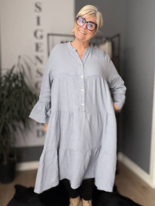 Ella er en lækker kjole i facon, som er en en behagelig ble-kvalitet i bomuld. Den er med stolpelukning og har en rigtig god pasform. Til plus size kvinder i str. 42 til 54.