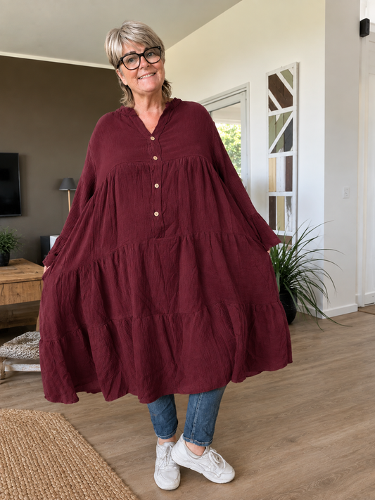 Ella plus size kjole i mørk marineblå med V-hals, knapper, 3/4 ærmer og flot vidde – stylet med sorte leggings og karamel sneakers.
Billed er ai generet