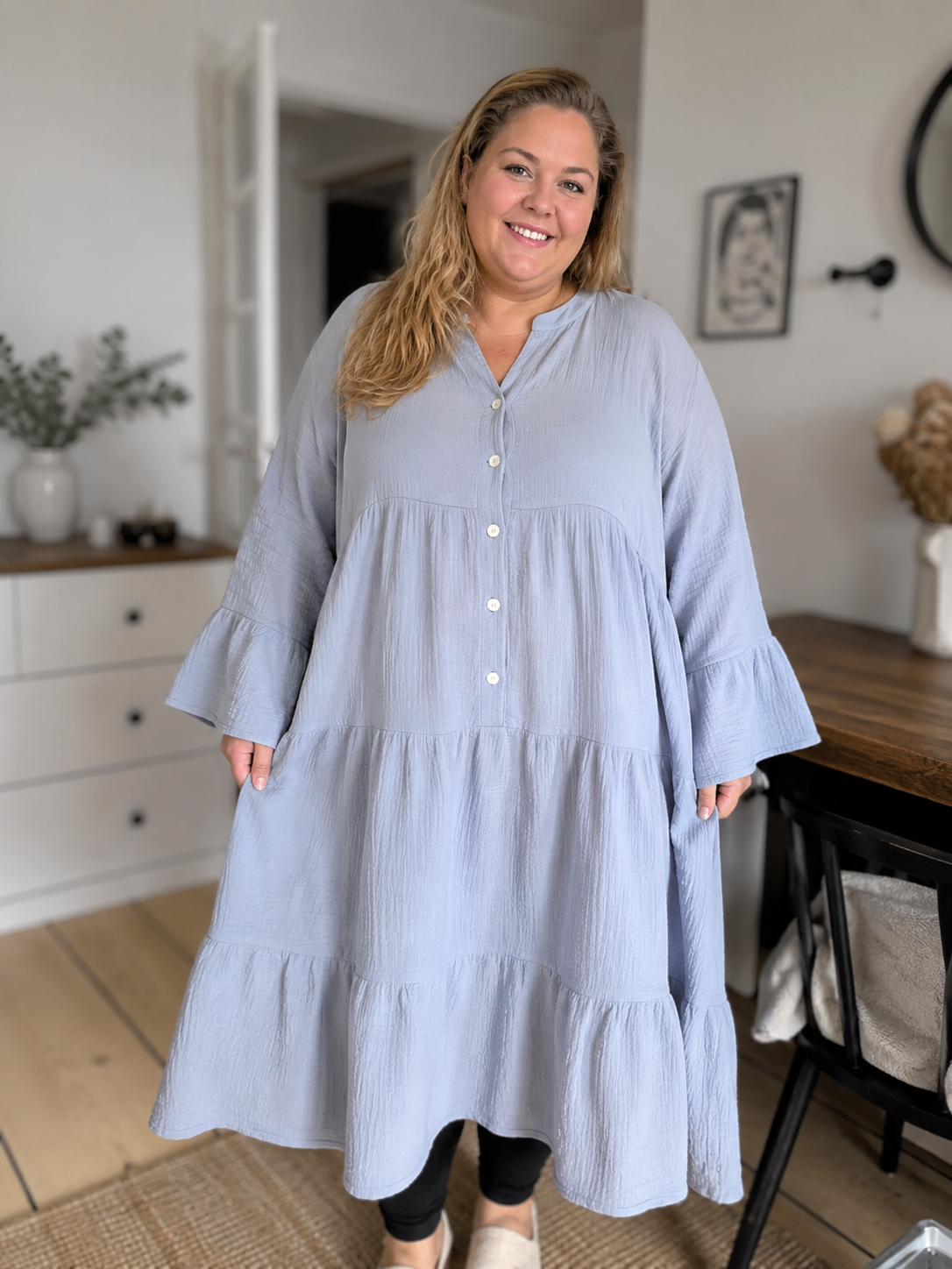 Ella er en lækker kjole i facon, som er en en behagelig ble-kvalitet i bomuld. Den er med stolpelukning og har en rigtig god pasform. Til plus size kvinder i str. 42 til 54.

Billedet er genereret vha. AI for at vise kjolen på en person. 