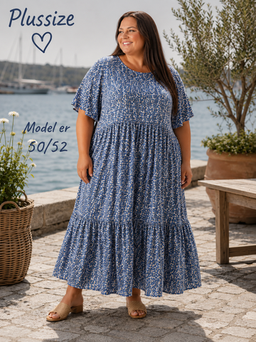 Denne smukke kjole er samme gode facon som vores Lolli kjole. Denne model er bare med blomster-print i stedet. 

Billedet er AI-genereret for at vise kjolen på et menneske.