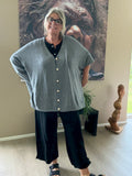 Denne smarte plus size cardigan er i en strik kvalitet, og så er faconen oversize med et stort brystmål fra ærme til ærme. Den er med knaplukning og kan både bruges åben og lukket. 