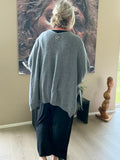 Denne smarte plus size cardigan er i en strik kvalitet, og så er faconen oversize med et stort brystmål fra ærme til ærme. Den er med knaplukning og kan både bruges åben og lukket. 