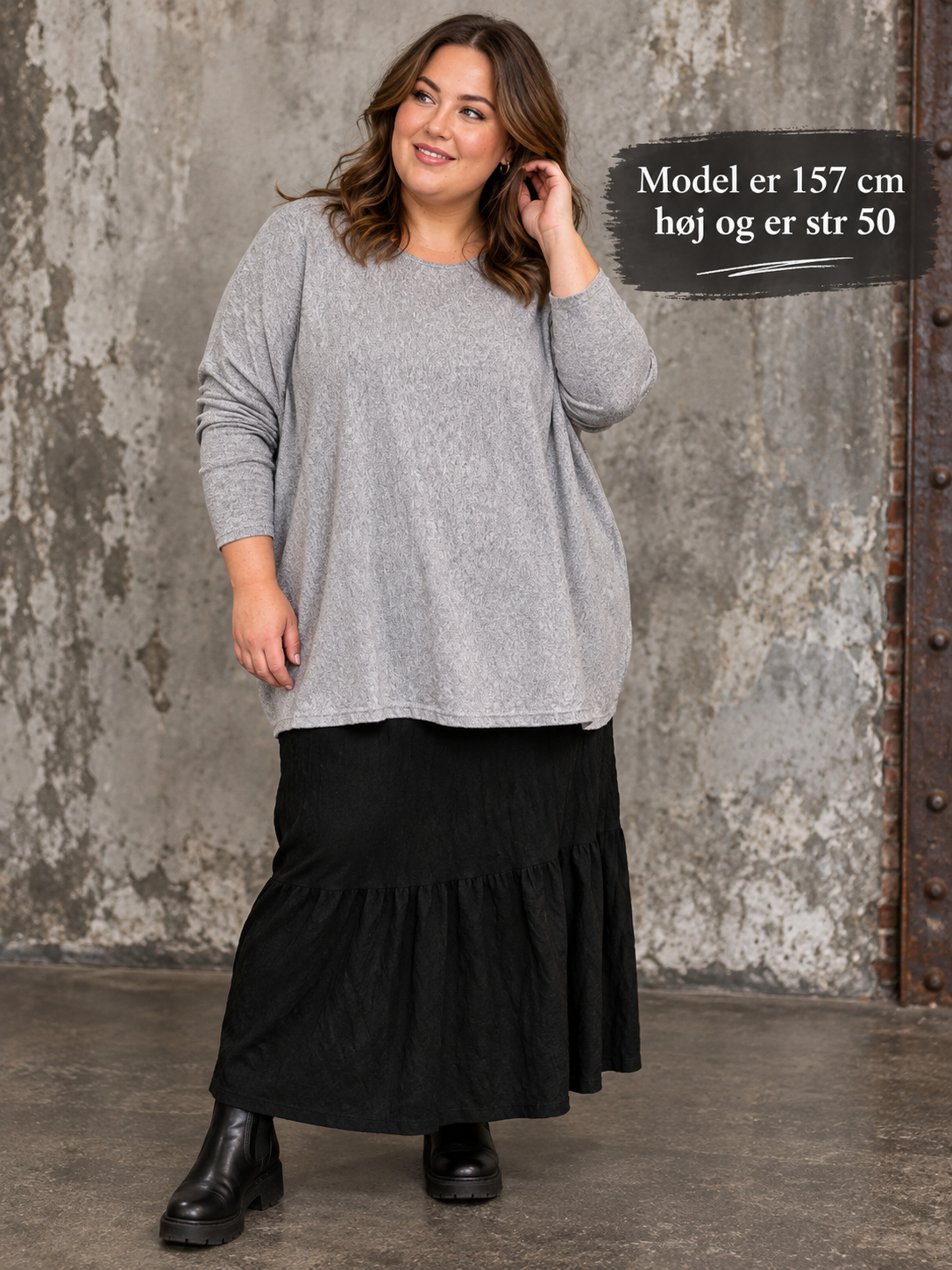 Ebba plussize strik  med rund hals, lange ærmer og løs oversize pasform.  Billedet er AI-genereret.
