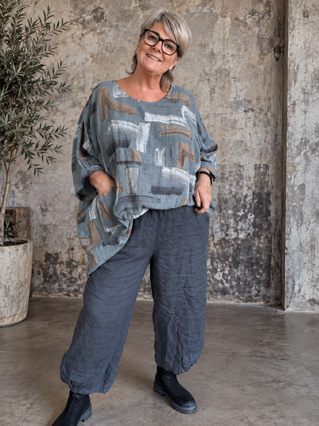 AI-genereret billede af Sille plussize bomuldstunika i let vævet bomuld med grafisk print, rund hals og lommer. Tunikaen vises på en plus-size model og fås i flere farver.