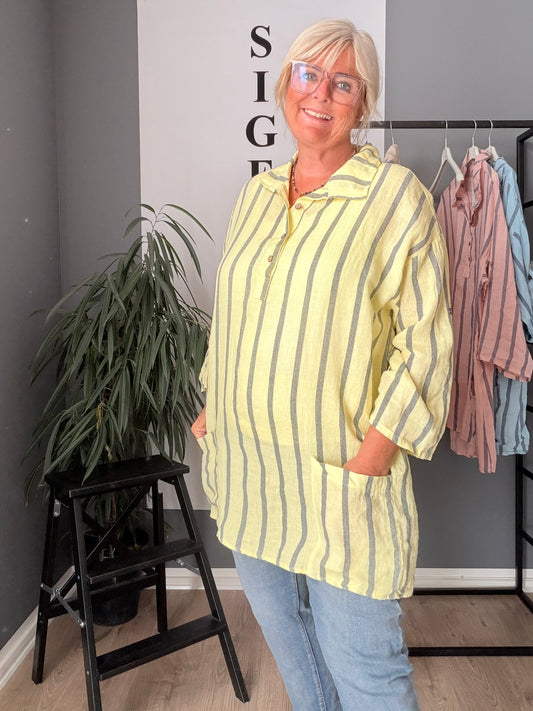 Luftig og komfortabel Ulla hørtunika designet til pluspiger. Tunikaen er fremstillet i let og åndbart hørmateriale, der gør den ideel til varme dage. Den har en løs, flatterende pasform, 3/4 del langt ærme med elevator hejs, stilren silhuet, som giver god bevægelsesfrihed. Perfekt til både hverdag og afslappede sommeranledninger. Kan styles med leggings eller bukser for et afslappet og moderne look.