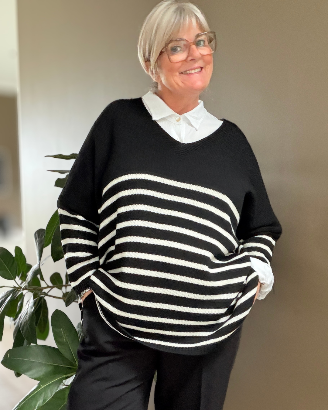Hille plussize strik med hvide striber og V-hals, vist på plus size model. Billedet er AI-genereret.