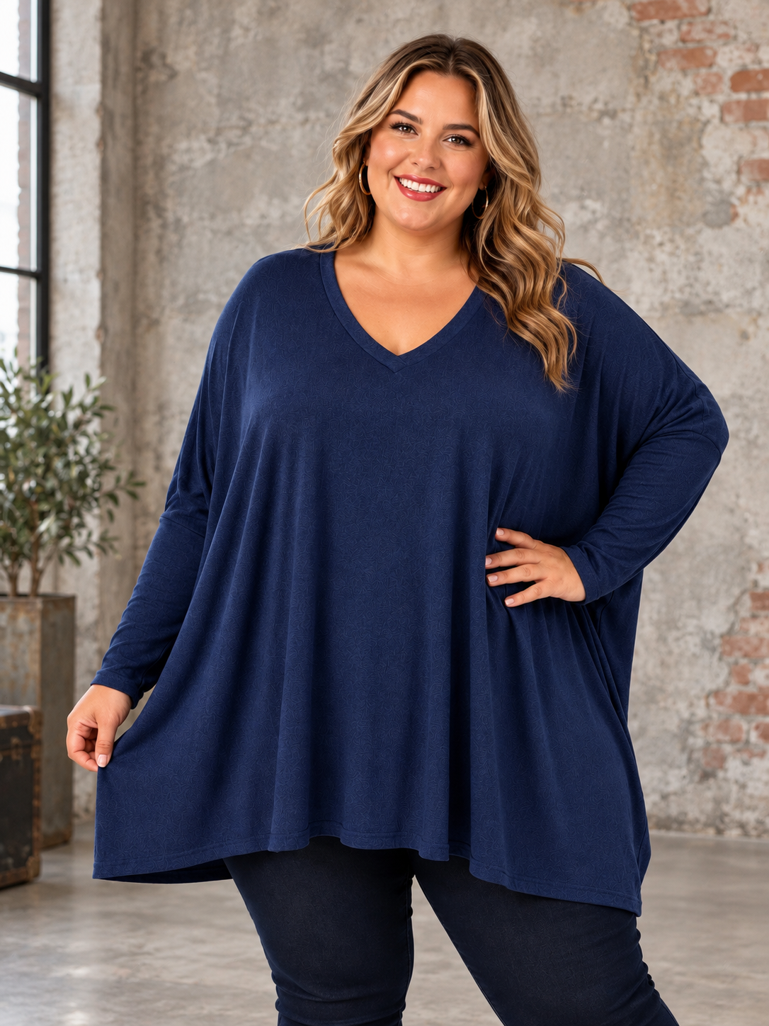 Hanne plussize strik i blød kvalitet med V-hals, lange ærmer og løs, rummelig pasform. Vist på plus size model – billedet er AI-genereret.