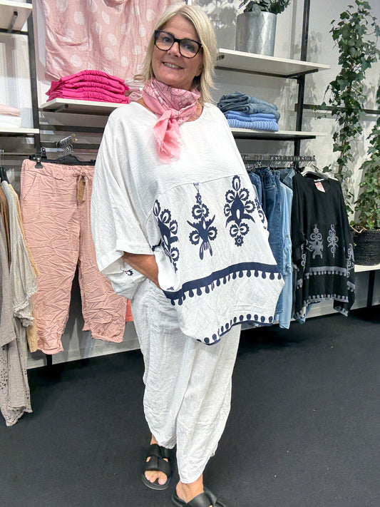 Lækker plus size tunika i viskose. Den har et fantastisk brystmål på 200cm, og så har den to lommer foran, hvor der også er en smukt mønster. Her ses tunikaen i farven hvid.