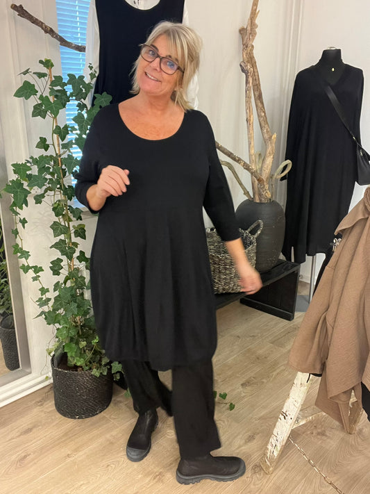 Hilda er plus size kjolen, som du vil elske. Modellen har en fin ballon-effekt, som er perfekt til de fleste plus size kvinder. Kvaliteten er en lækker viskose. Derudover har den 3/4 ærmer og rund hals. Her ses den i sort. 
