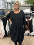 Hilda er plus size kjolen, som du vil elske. Modellen har en fin ballon-effekt, som er perfekt til de fleste plus size kvinder. Kvaliteten er en lækker viskose. Derudover har den 3/4 ærmer og rund hals. Her ses den i sort. 