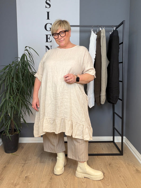 Hulda plussize hørkjole i let og åndbar hørkvalitet, designet med en flatterende pasform til kurvede kvinder. Kjolen har et tidløst og feminint snit, der falder smukt over kroppen og giver høj komfort hele dagen. Perfekt plussize kjole i hør til både hverdag og fest, ideel til varme dage med fokus på naturlige materialer, bevægelsesfrihed og stilrent udtryk