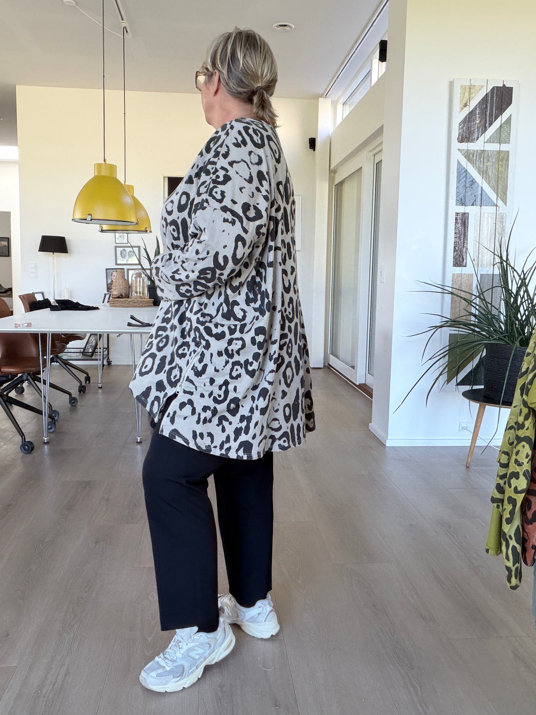 Smart leopard tunika med lange ærmer, som her har fået et ombuk. Den er med rund hals og en god længde. billed er ai generet