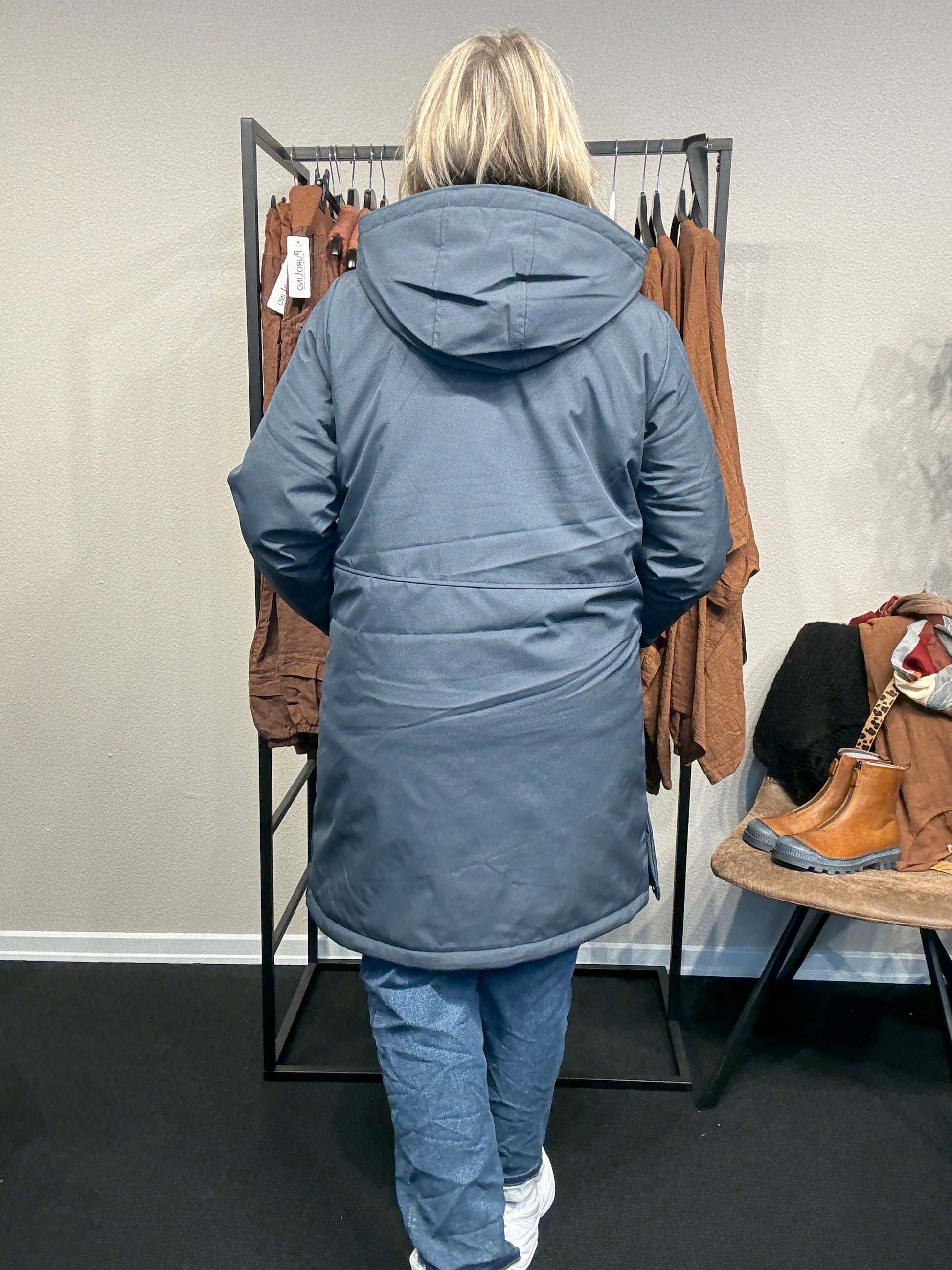 Smart og funktionel plus size jakke efterårs/vinter jakke hvor der er mulighed for at knappe en smule op i siden. Den er med lange ærmer, hætte og så har den lynlås lukning hele vejen ned, samt lommer med lynlås. Rigtig god længde som går til lige under knæet.
