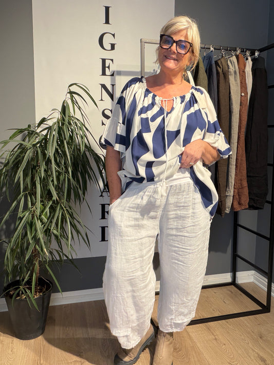 Lækker viskose tunika i sort og hvid stor i hals og med brede luftige ærmer pussize fra sigensgaard.dk