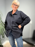 ILSE er en klassisk og stilren skjorte i plus size med et tidløst design og god pasform. Skjorten er gennemknappet og har lange ærmer, hvilket gør den alsidig og nem at style både lukket som en almindelig skjorte eller åben som en let, løs skjorte.