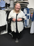 Lækker plus size skjorte, som passer fra en str. 42 til ca. 50+. Den er gennemknappet, og har to snydelommer på brystet. Derudover er der elevatorhejs ved ærmet. Her ses den i farven kalk. 