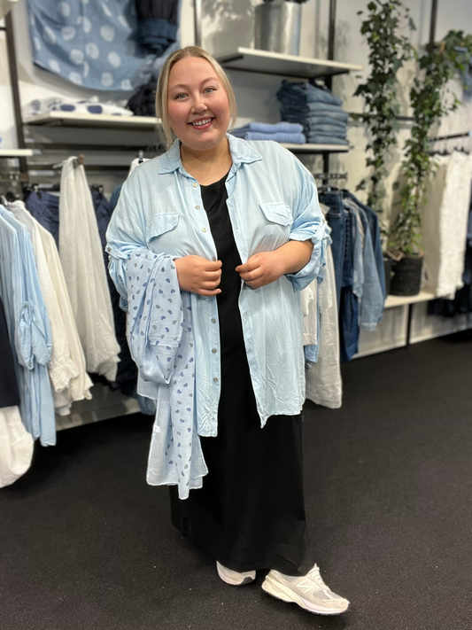 Inge er plus size skjorten, som kan passes af de fleste. Den er dejlig lang, da den har en længde på hele 84cm. Brug den som en åben jakke eller helt lukket, den er nemlig gennemknappet. 