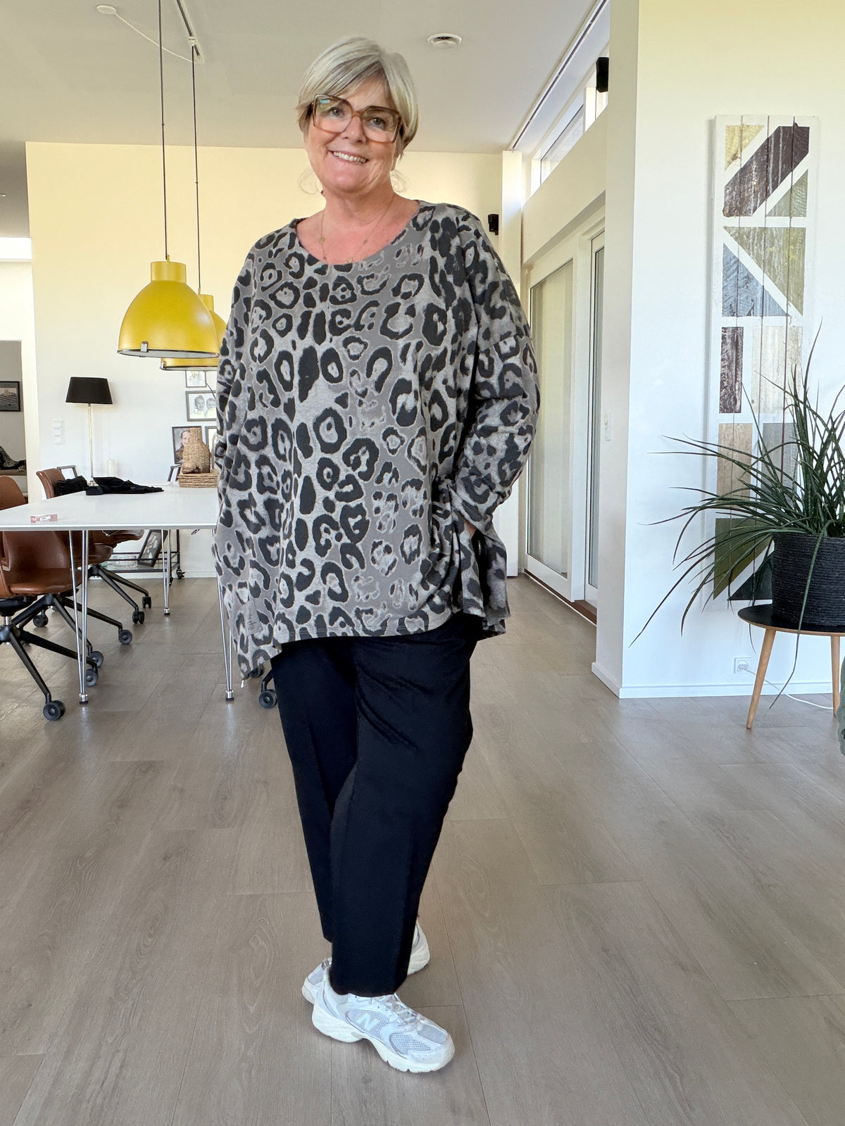 Smart leopard tunika med lange ærmer, som her har fået et ombuk. Den er med rund hals og en god længde. billed er ai generet